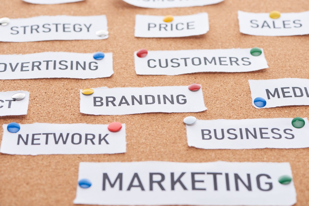 Marketingwoorden op prikbord met punaises.